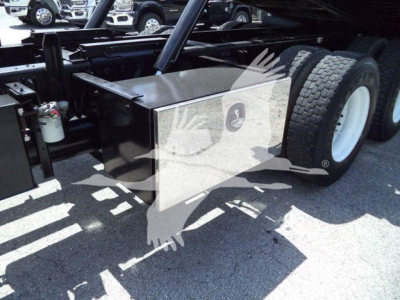 Peterbilt 348 rollback truck rear chassis area with dual rear tires and a metal toolbox mounted near the frame.