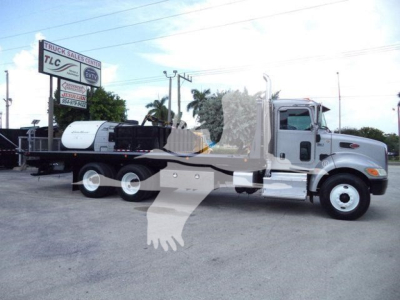 Peterbilt 348 rollback truck with cab and flatbed, side view; includes text signs in background but focus on truck.