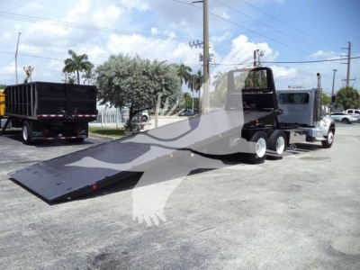 Peterbilt 348 rollback truck with flatbed and towing equipment, side view showing dual rear axles and extended ramp, used vehicle.