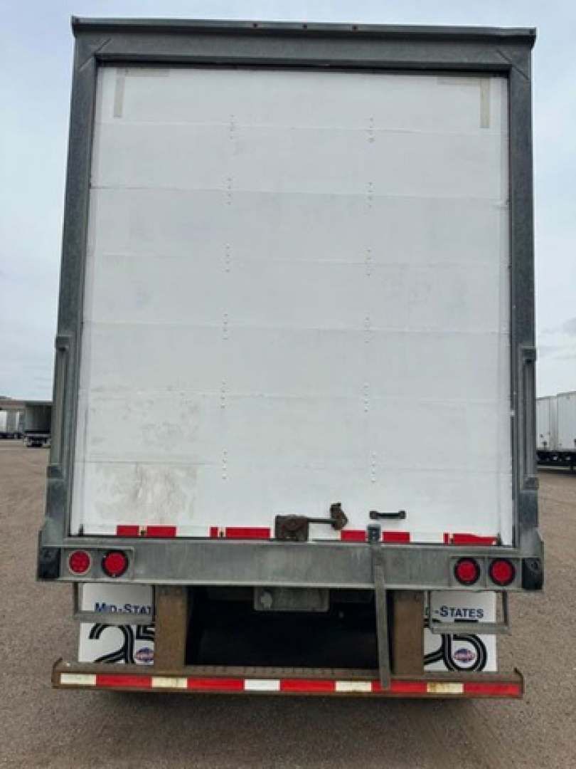 Rear view of a white Wabash van trailer showing rear bumper and lights with license plate areas and reflective tape.
