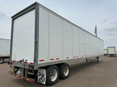 Semi-trailer van showing dual rear wheels and aluminum side panels with red and white reflectors along the lower edge.