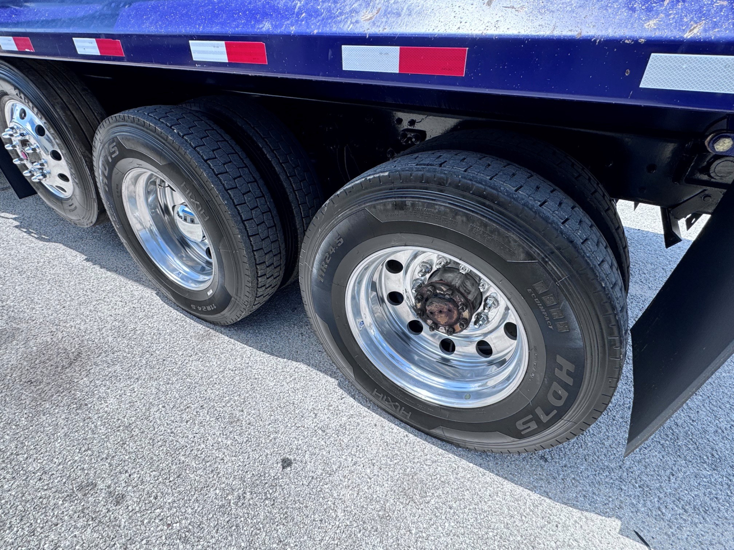 Kenworth T880 wheel area showing dual rear axles with polished aluminum rims and Hoosier tires.