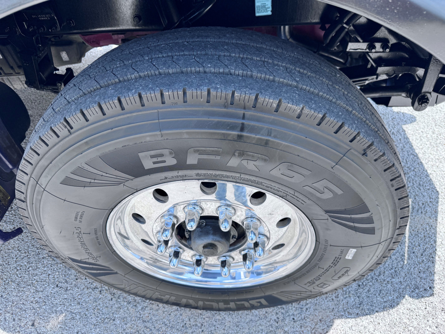 Tire and wheel assembly of a 2023 Kenworth T880 dump truck showing BFGoodrich tire and lug nuts.