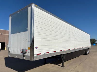 Utility refrigerated trailer in side view showing aluminum exterior and rear doors with hitch, jack, and wheel area.
