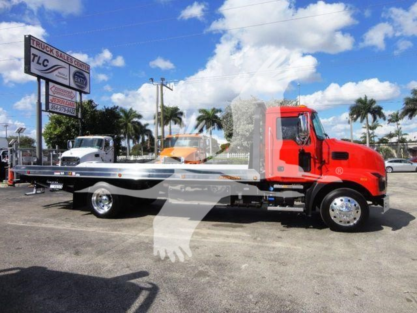 Tow truck on lot with red cabin and flatbed, 2027 Mack Md6, stock J04541, new rollback category.