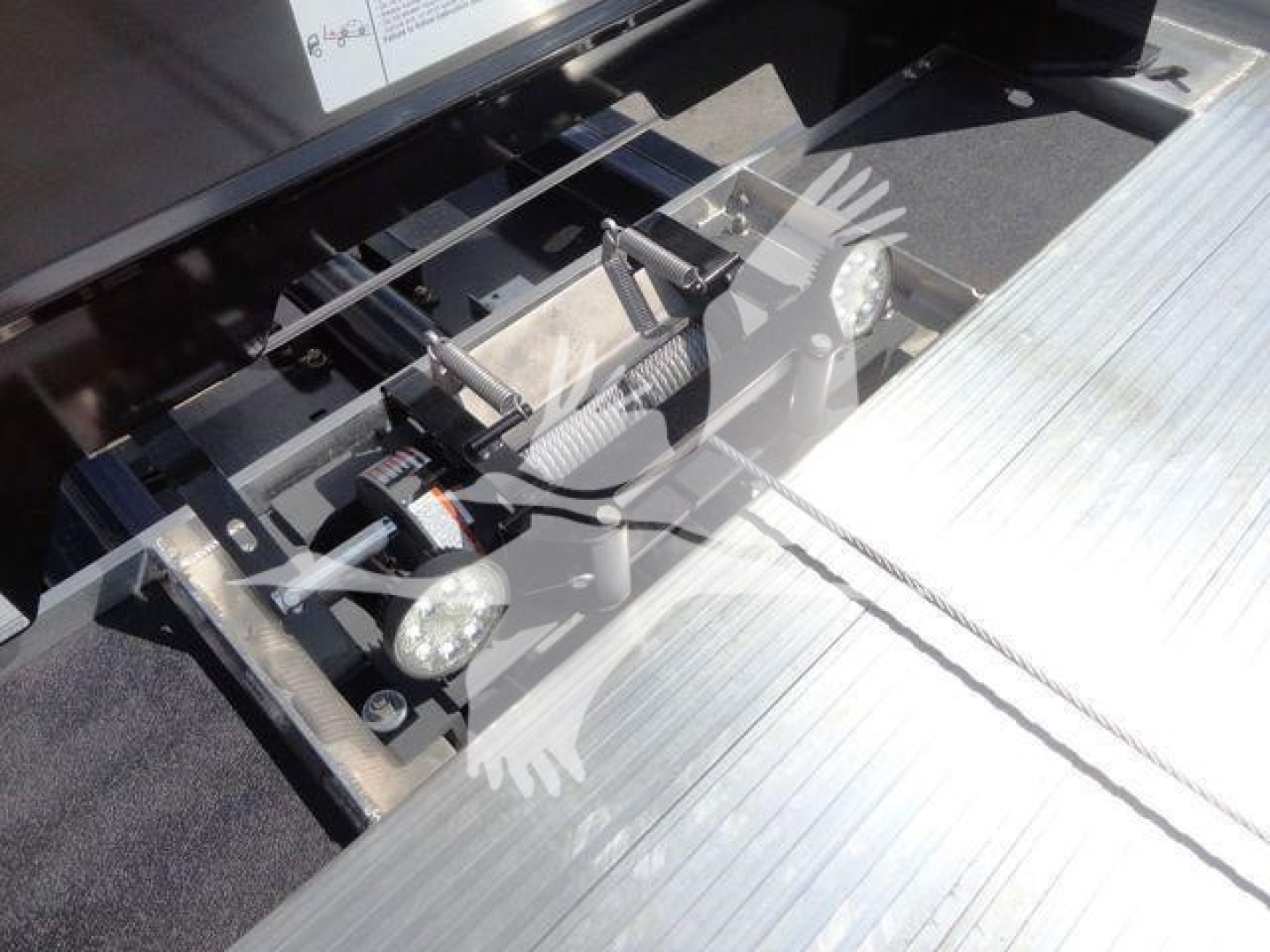 Front view of a 2027 Mack MD6 rollback truck hitch assembly with hydraulic components and steel platform surface.