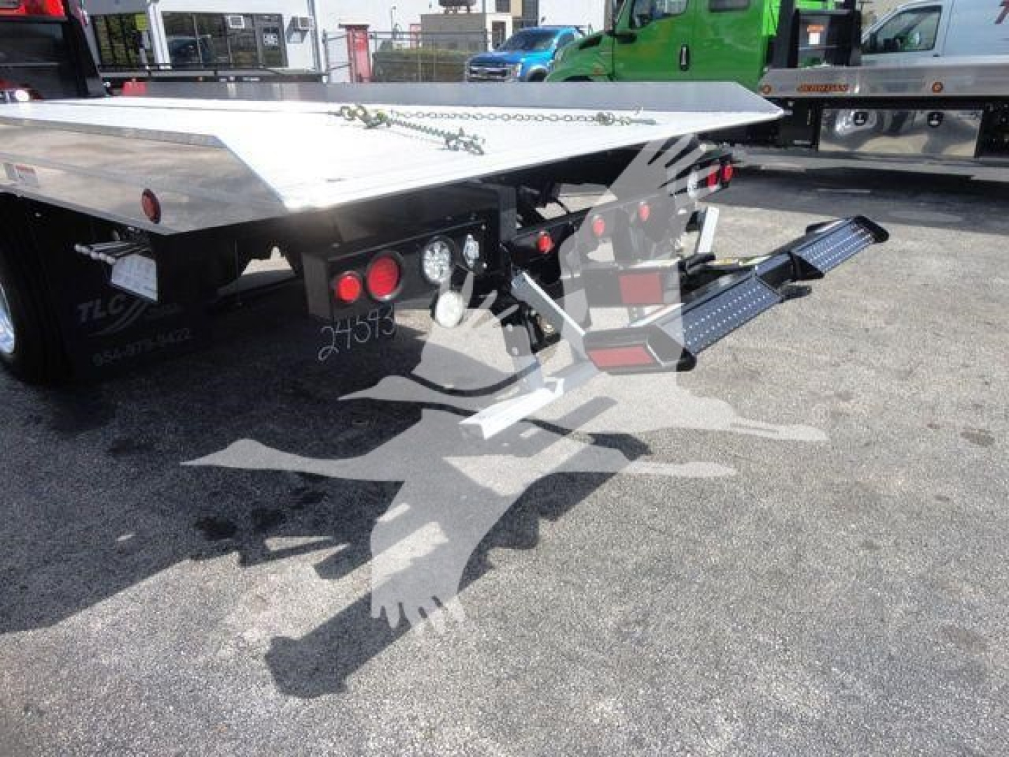 MD6 rollback truck flatbed showing rear platform and ramp/loader with metal steps and taillights visible.