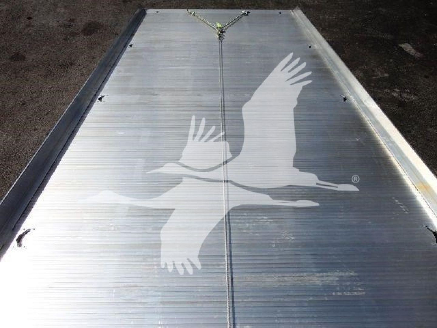 Aluminum Mack MD6 rollback truck bed or platform with a welded seam and chain hitch, showing a white gulls graphic logo.