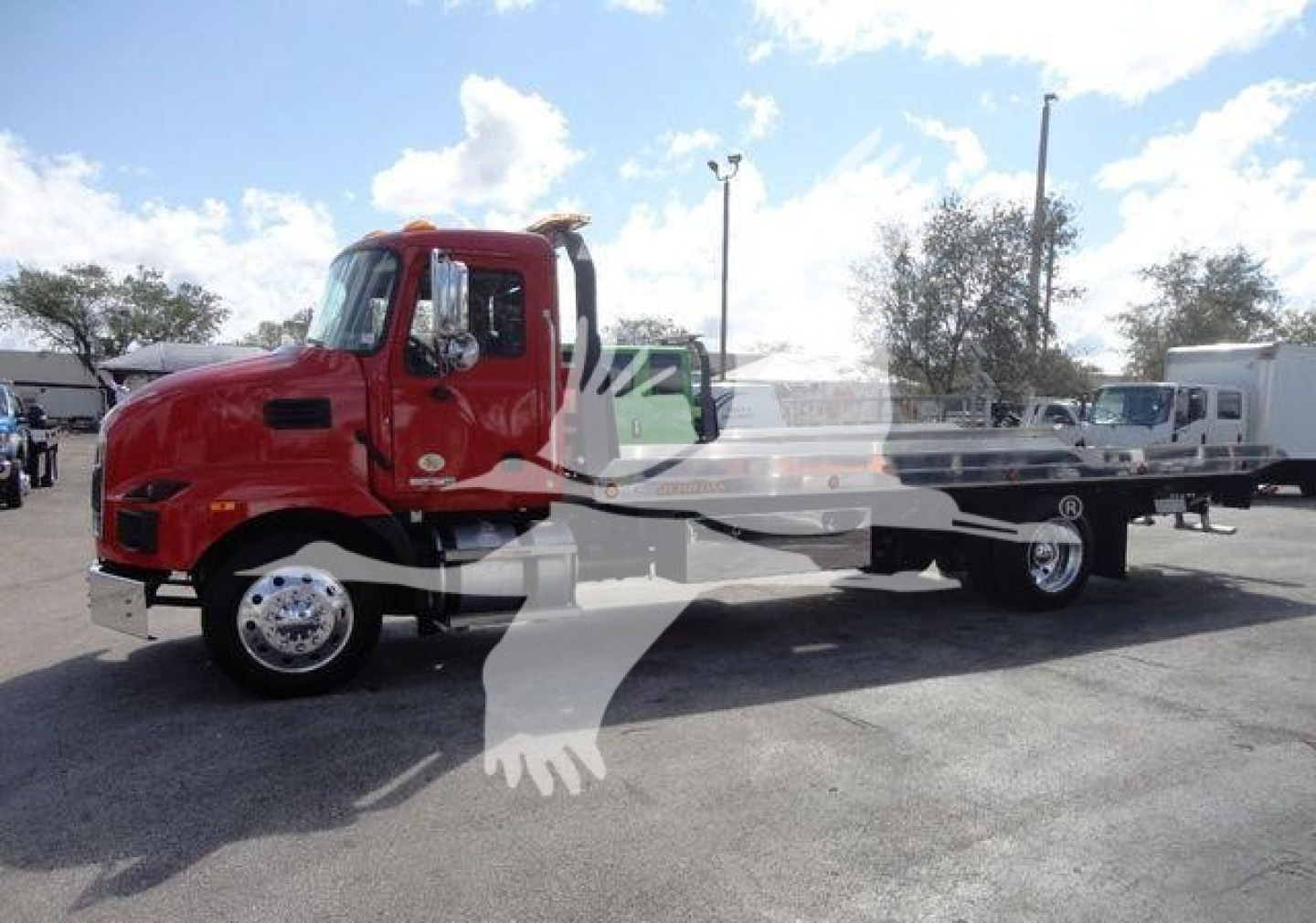 Red Mack MD6 rollback truck with flatbed, side view showing cab and long bed.