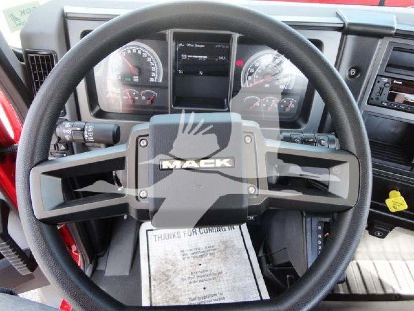 Mack MD6 truck steering wheel and dashboard with Mack logo on steering wheel, digital and analog gauges visible.