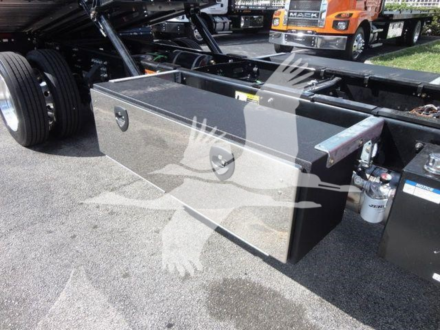 Truck chassis with a large metallic tool/storage toolbox mounted under the frame near the rear wheel and a cylindrical air filter or canister.