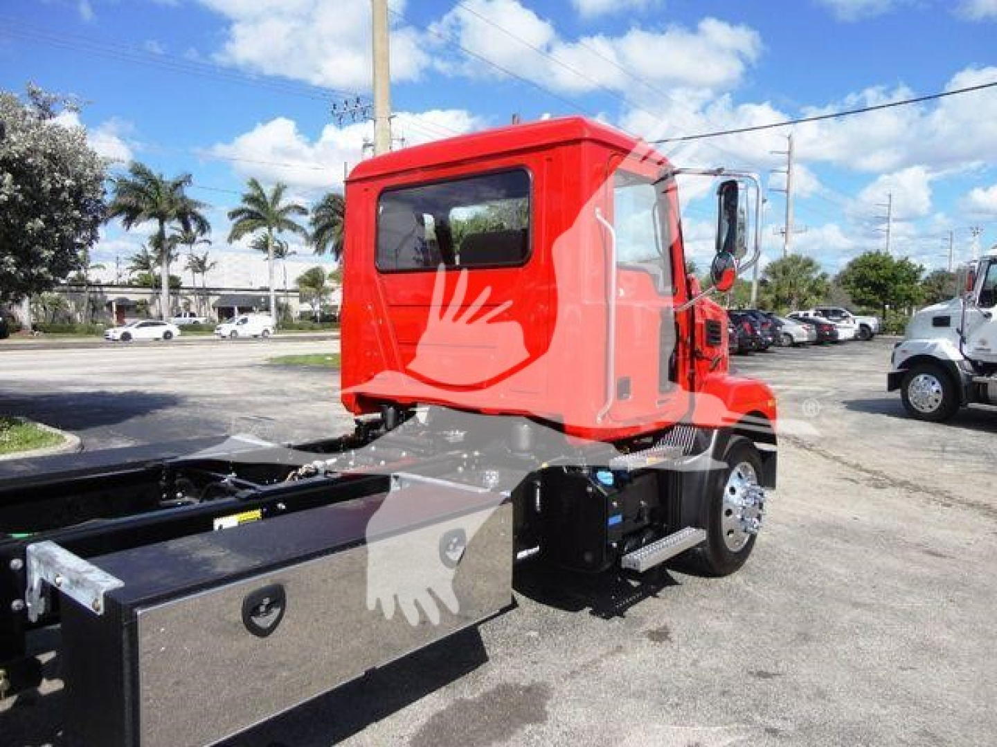 MD6 truck cab side view showing bright red exterior and black rollback hoppers with chassis in foreground.