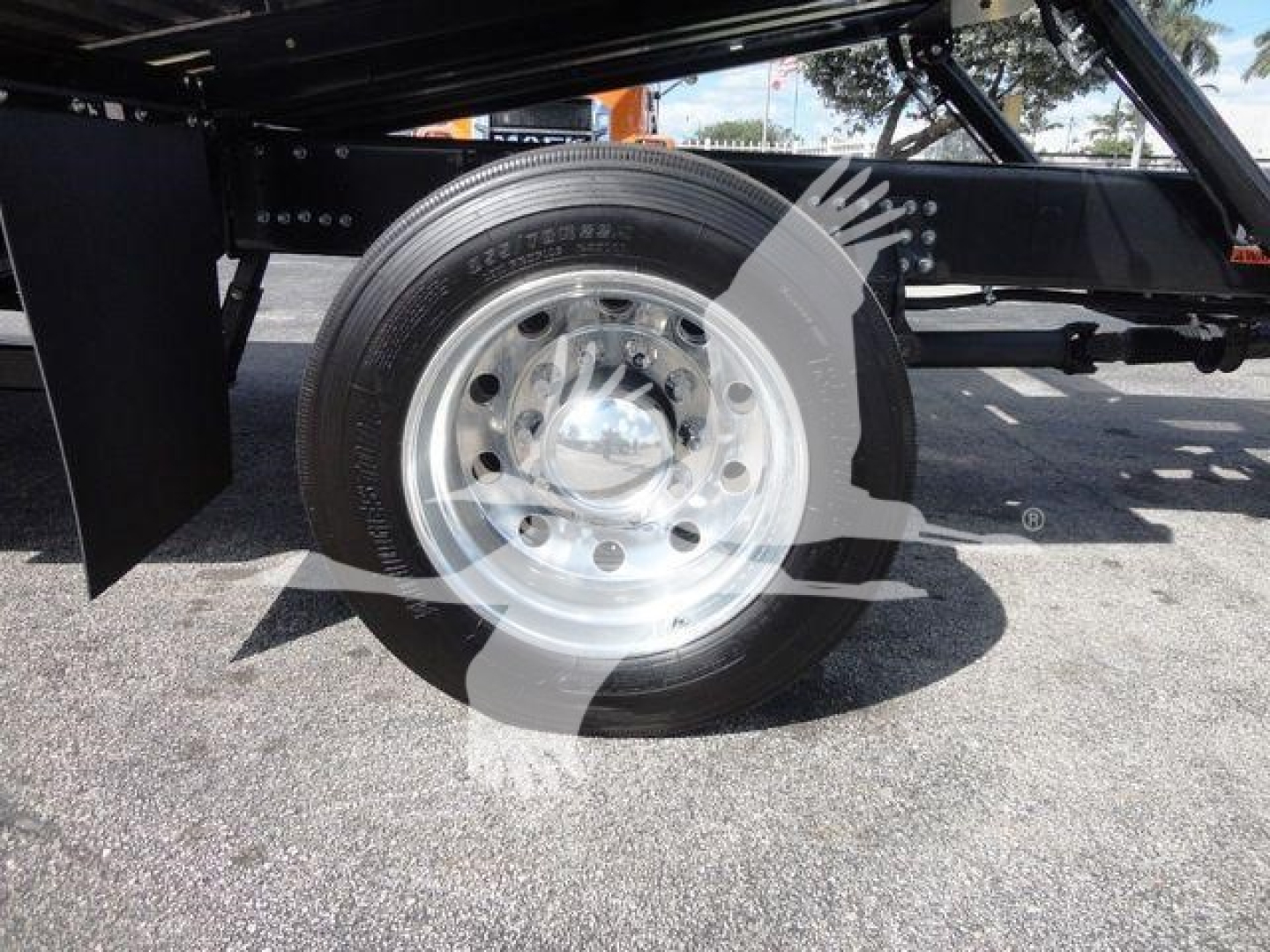 Truck wheel and chassis components on a Mack Md6 rollback truck showing a steel rim with tire and part of the suspension.