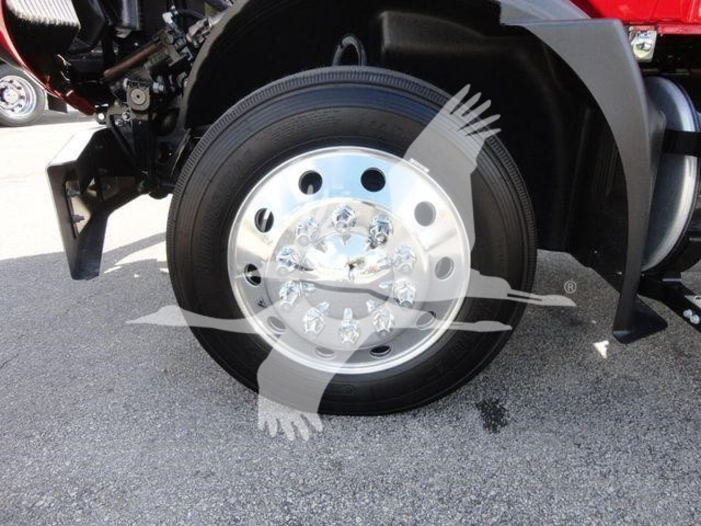 Truck wheel close-up showing chrome hubcap and tire on Mack MD6 rollback chassis.