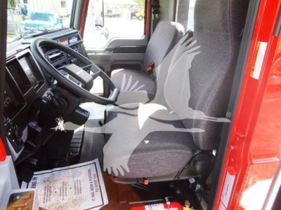 Interior of a 2027 Mack MD6 cab showing driver seat and dashboard with steering wheel and keys in ignition.