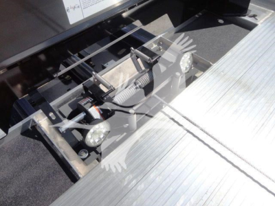 Front view of a 2027 Mack MD6 rollback truck hitch assembly with hydraulic components and steel platform surface.