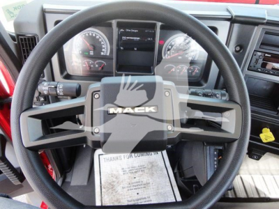 Mack MD6 truck steering wheel and dashboard with Mack logo on steering wheel, digital and analog gauges visible.