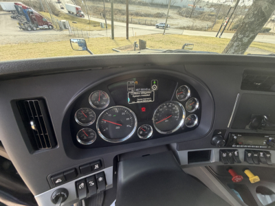 Dashboard of a 2020 Kenworth T680 truck showing multiple gauges, warning lights, and central display screen.