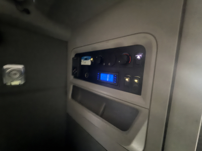 Kenworth T680 dash panel showing dashboard controls and blue digital display.