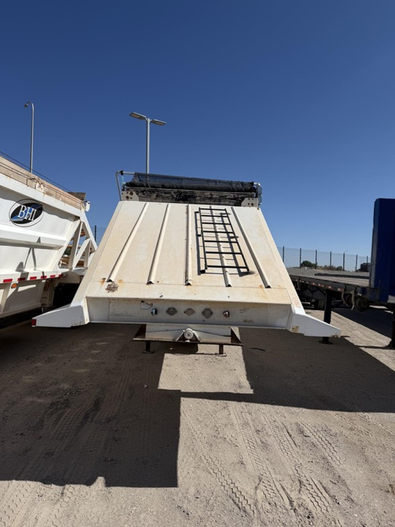 Dump trailer rear view showing steel bottom with ladder access and air ride mechanism.