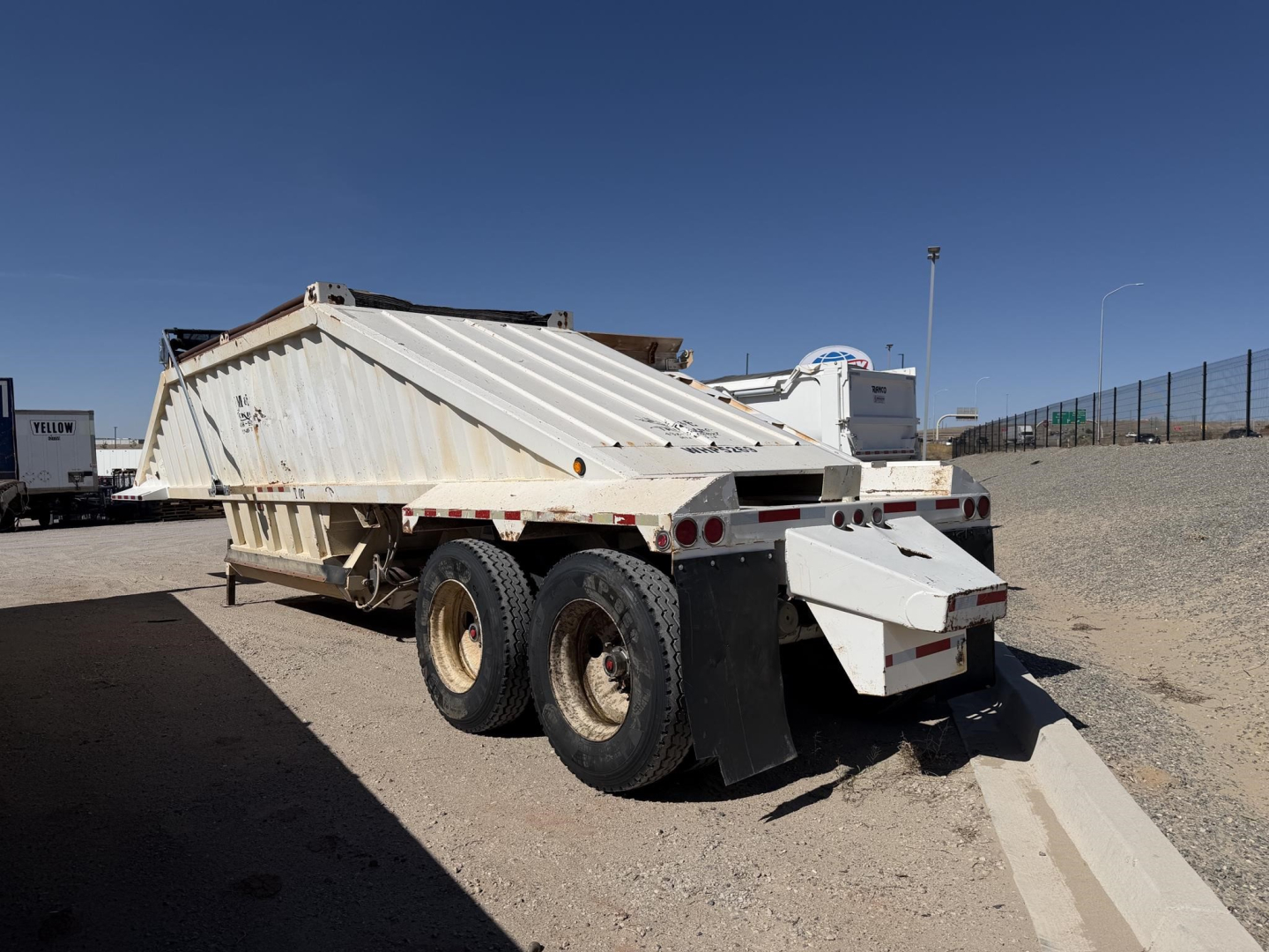 Construction trailer specialist air ride steel bottom dump with electric tarp showing rear and side view.