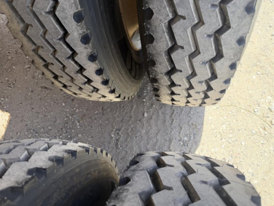 Dual rear tires of a dump trailer show rugged tread patterns and wheel hubs.