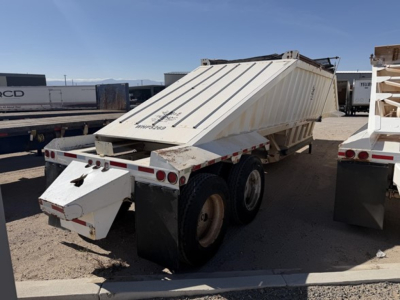 Dump trailer with air ride, steel bottom, rear view showing hydraulic tailgate and dual rear axles; white with reflective tape.