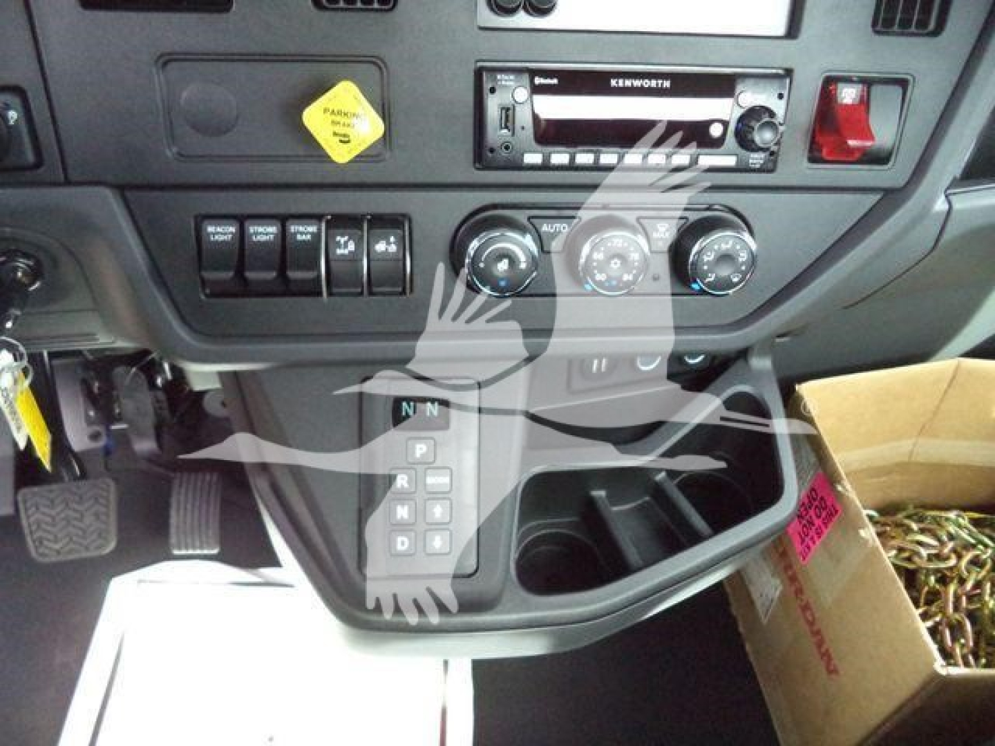 Kenworth T280 interior dash view showing gear selector, climate controls, and radio in a new/unused truck. Center console includes cup holders and storage pocket.