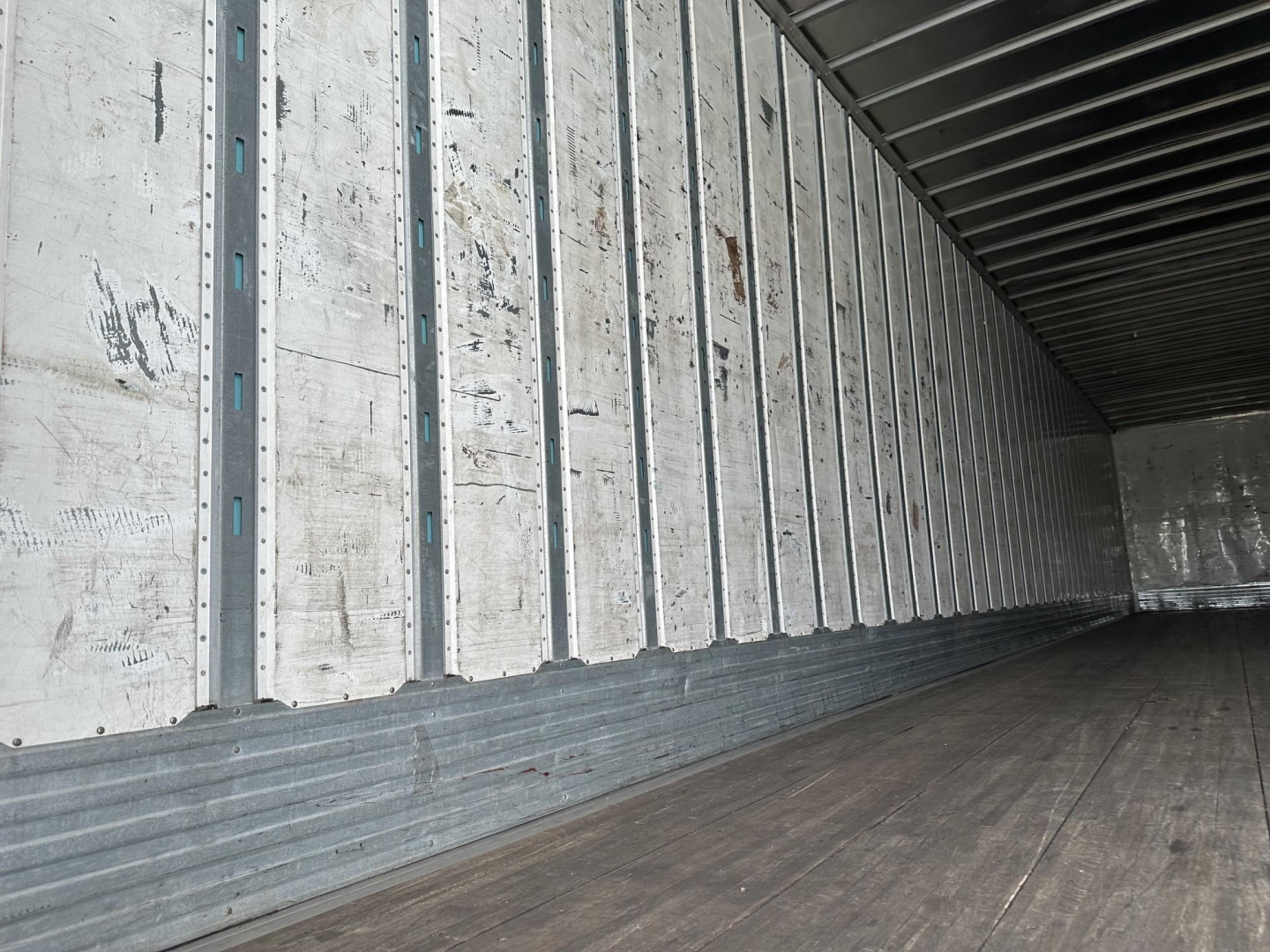 Interior of a 2016 Utility 4000DX trailer showing metal side walls, wooden floor, and cargo area.
