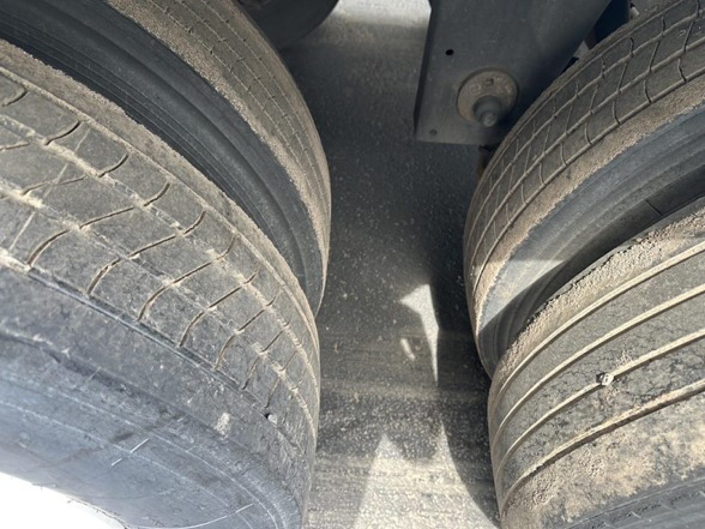 Dual rear trailer tires on a Utility 4000Dx trailer, tread visible with some wear and dirt on the tire surfaces.