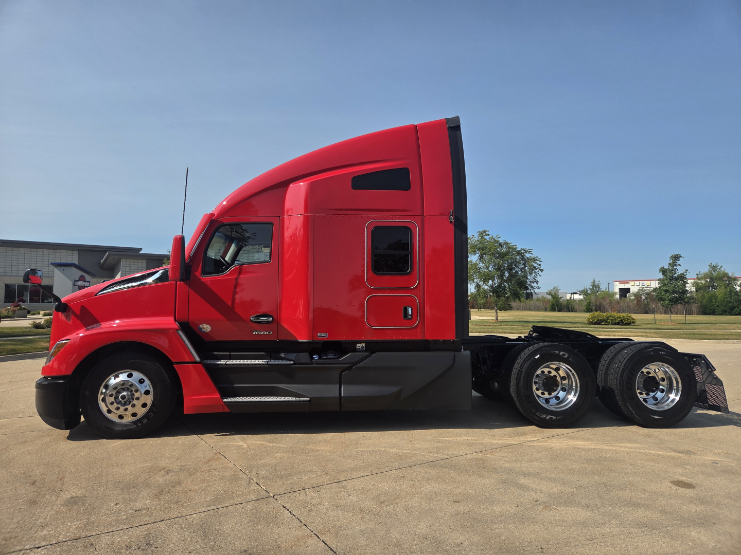 Kenworth T680 truck side profile showing red cab and sleeper with dual rear axles and chrome wheels.