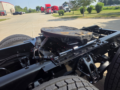 Kenworth T680 chassis and fifth wheel riser showing the drivetrain area and suspension undercarriage.