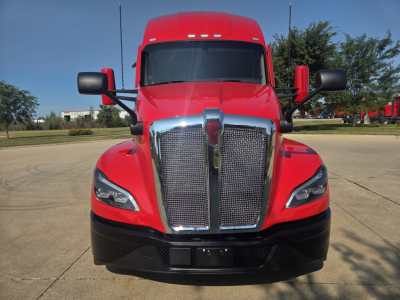 Front view of a red 2024 Kenworth T680 truck showing chrome grille, headlights, and side mirrors.