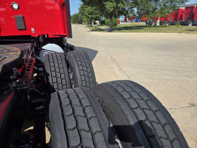 Kenworth T680 truck rear dual rear wheels and tire detail visible with red cab and chassis.