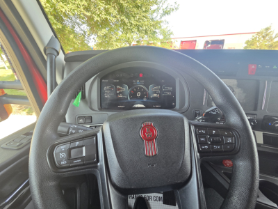 Kenworth T680 dashboard and steering wheel inside cab showing digital gauge cluster and controls.