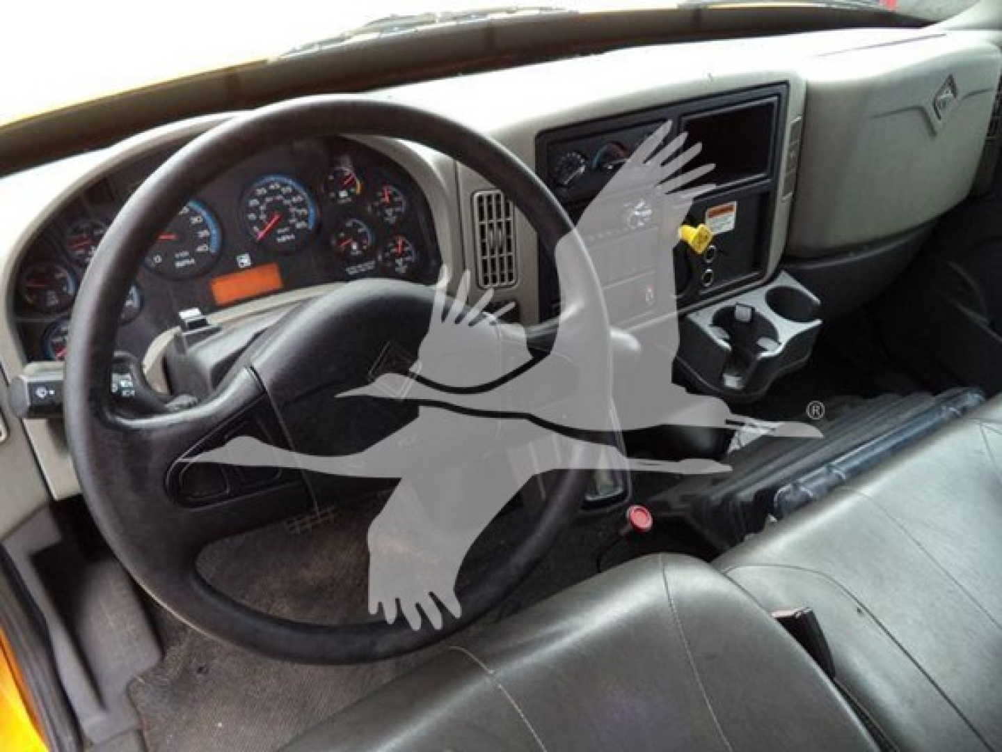 Dashboard view of a 2019 International Durastar 4300 dump truck cab showing steering wheel, instrument cluster, and center console with cup holders.