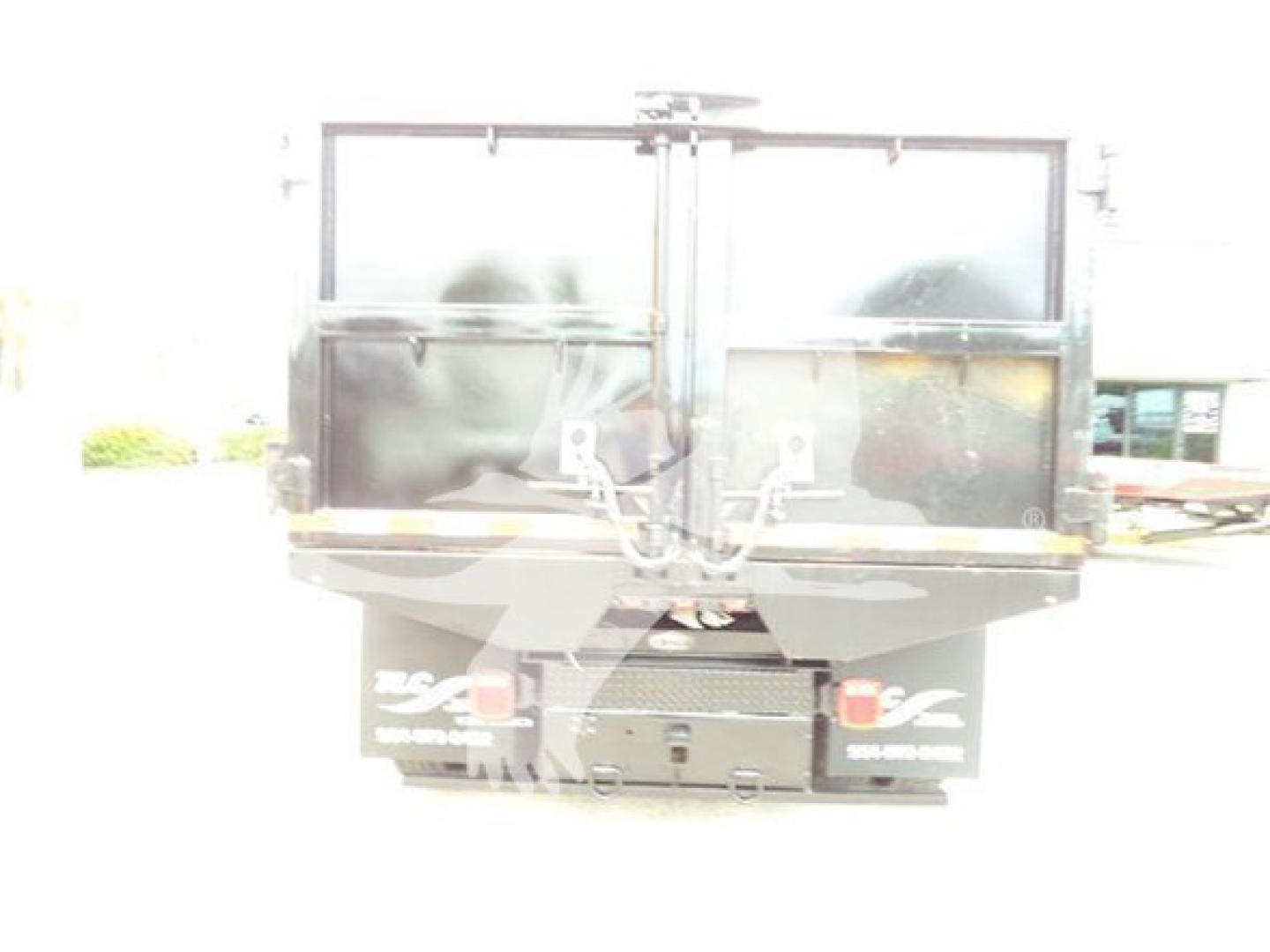 Back view of a 2019 International Durastar 4300 dump truck with rear gate and tailgate, showing cargo bed and bumper signs.