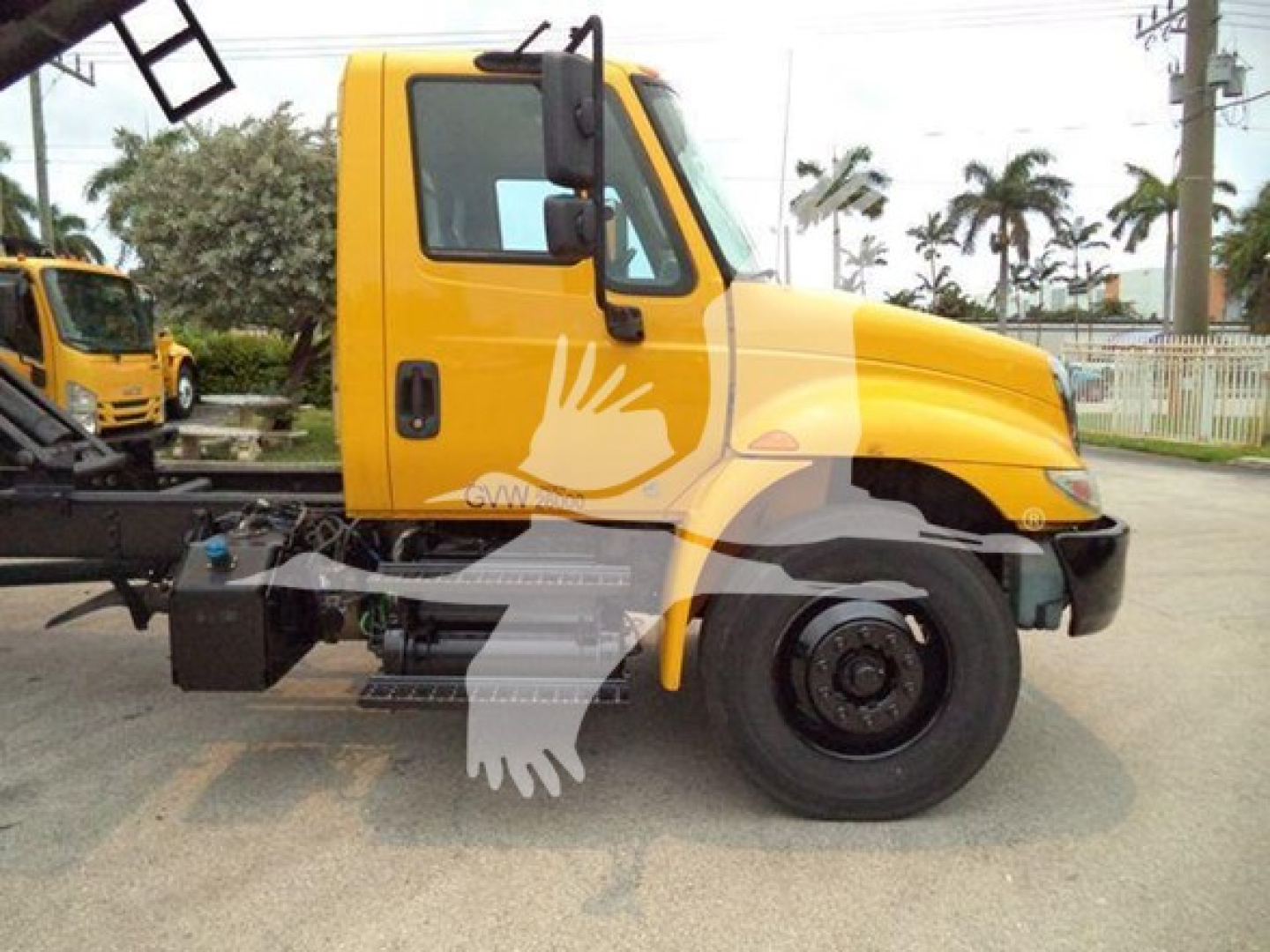Truck cab view of 2019 International Durastar 4300 with yellow body, side mirror, front wheel, and partial chassis visible; VIN 3HAMMMML2KL383586 and stock number T83586 shown on listing.