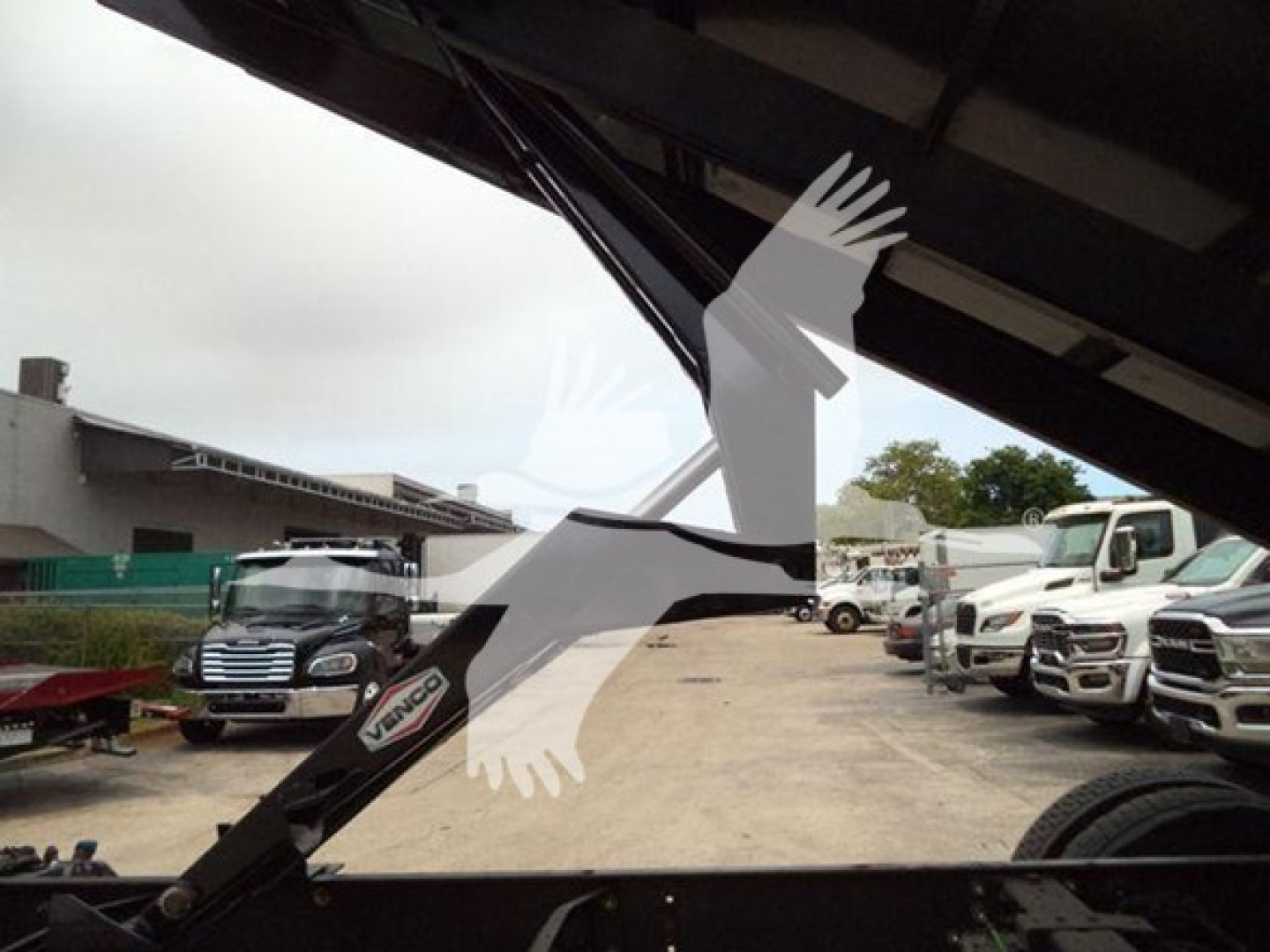 Dump truck hitch area of a 2019 International Durastar 4300 showing hydraulic crane/arm and VIN plate visible, stock number T83586.