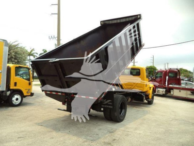Dump truck bed raised showing cargo bed of a 2019 International Durastar 4300 with other trucks in background.