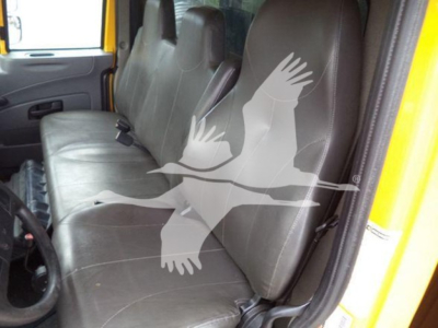 Truck cab interior with brown leather seats and a yellow exterior; no visible text on components.
