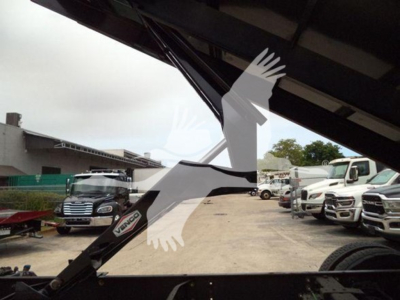 Dump truck hitch area of a 2019 International Durastar 4300 showing hydraulic crane/arm and VIN plate visible, stock number T83586.