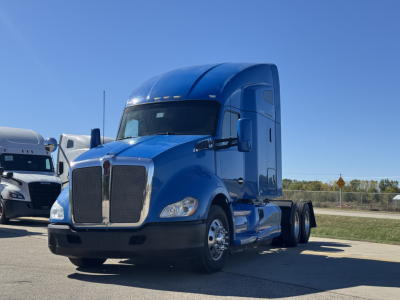 Kenworth T680 conventional sleeper truck in blue, front three-quarter view.