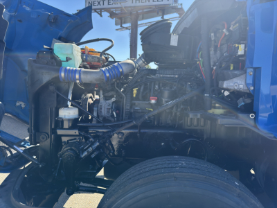 Kenworth T680 engine bay view showing intake hoses, coolant reservoir, and various engine components.