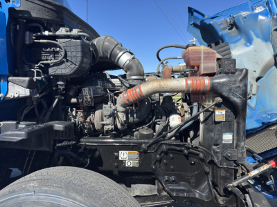 Kenworth T680 engine bay with hoses, radiator, and turbocharger visible; orange coolant hose and various engine components.