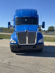Kenworth T680 conventional sleeper truck front view showing blue cab and chrome grille.