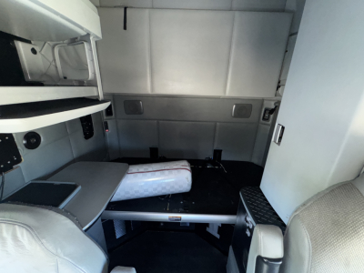 Truck sleeper cab interior of a 2015 Kenworth T680 showing a bunk bed area and storage compartments.