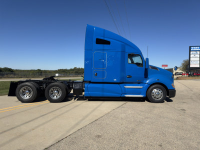 Blue 2015 Kenworth T680 sleeper cab truck from side view, features include long hood, dual rear axles, and a blue painted exterior.