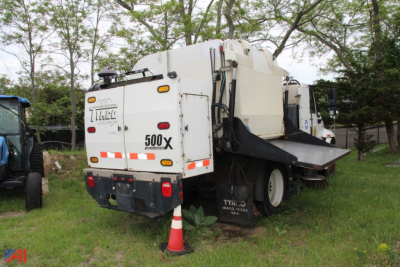 Chassis view of a 2010 International Tymco DuraStar 4300 sweeper with rear hopper, tail lights, and dual rear wheels.