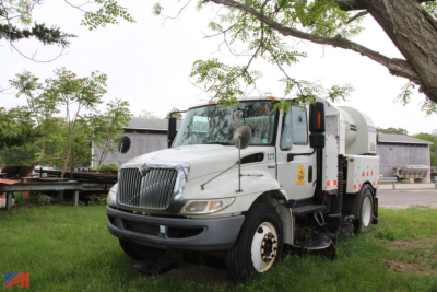Chassis of a 2010 International Tymco DuraStar 4300 sweeper truck viewing left front side with a white/gray body, mounted equipment behind cab.